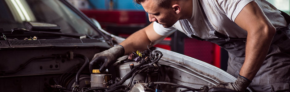 mechanic repairing vehicle under the bonnet